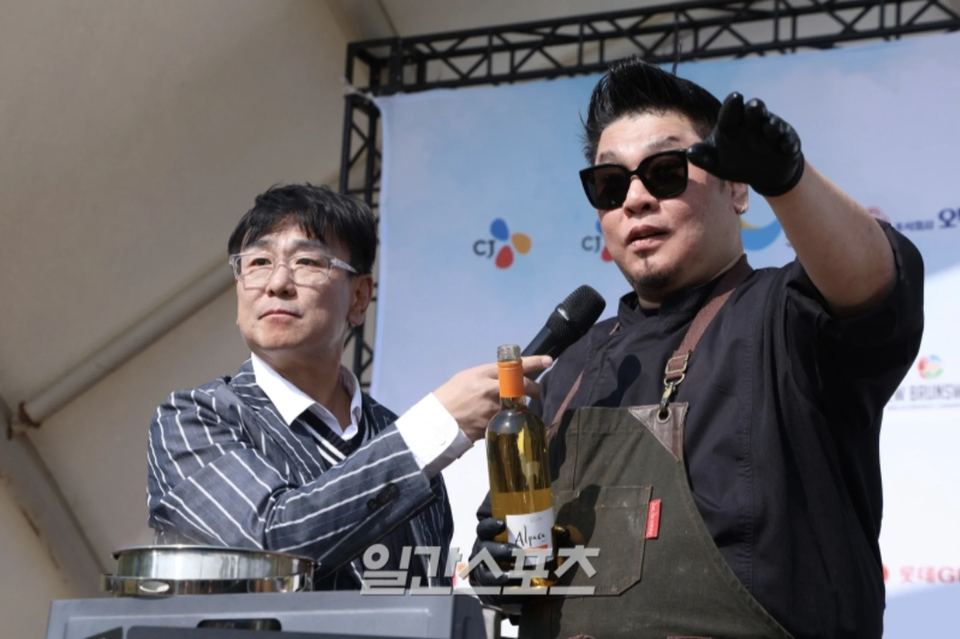 요리사와 마이크를 들고 대담하는 진행 장면 · 야외 축제 행사