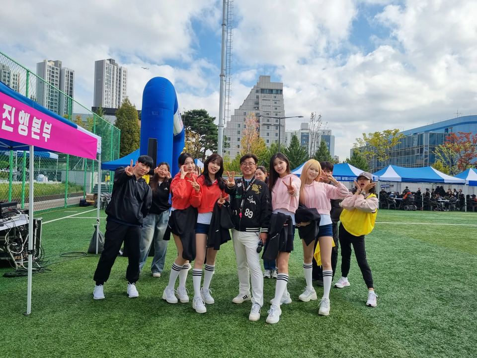야외 잔디 행사장에서 응원단과 함께한 단체 사진 · 야외 축제 행사