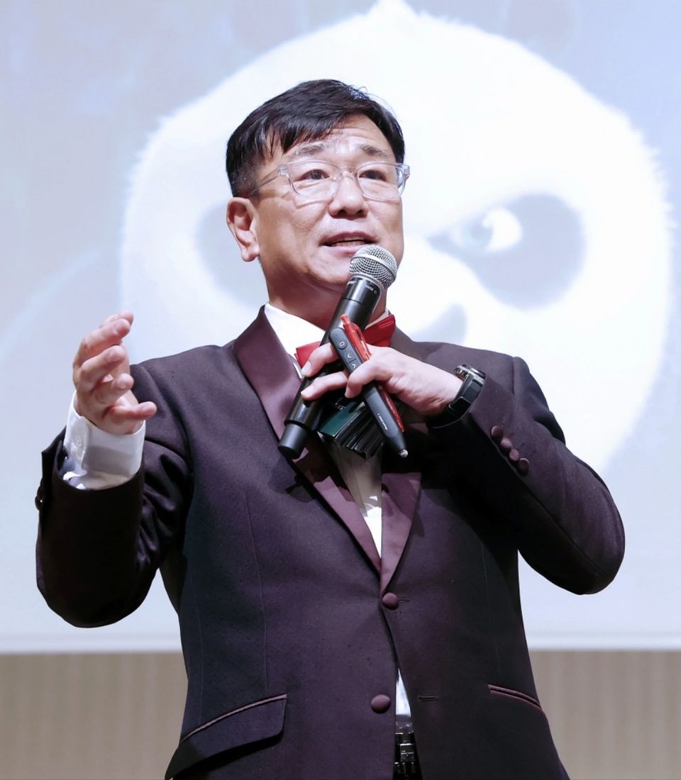 마이크를 들고 무대에서 컨퍼런스를 진행하는 MC 신용주
