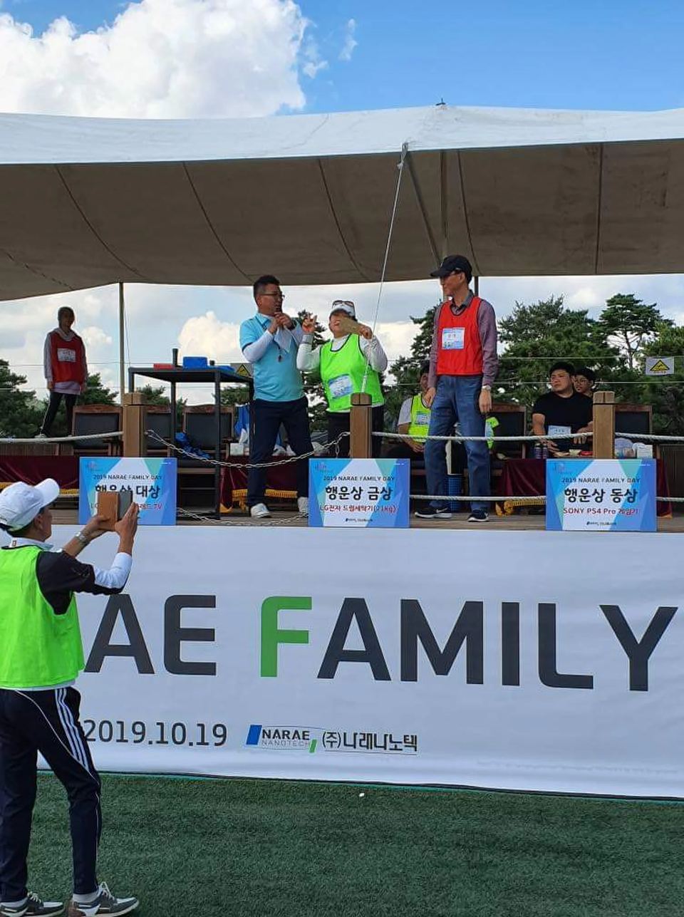 야외 무대 위 시상 준비 중인 진행 장면 · 기업 행사