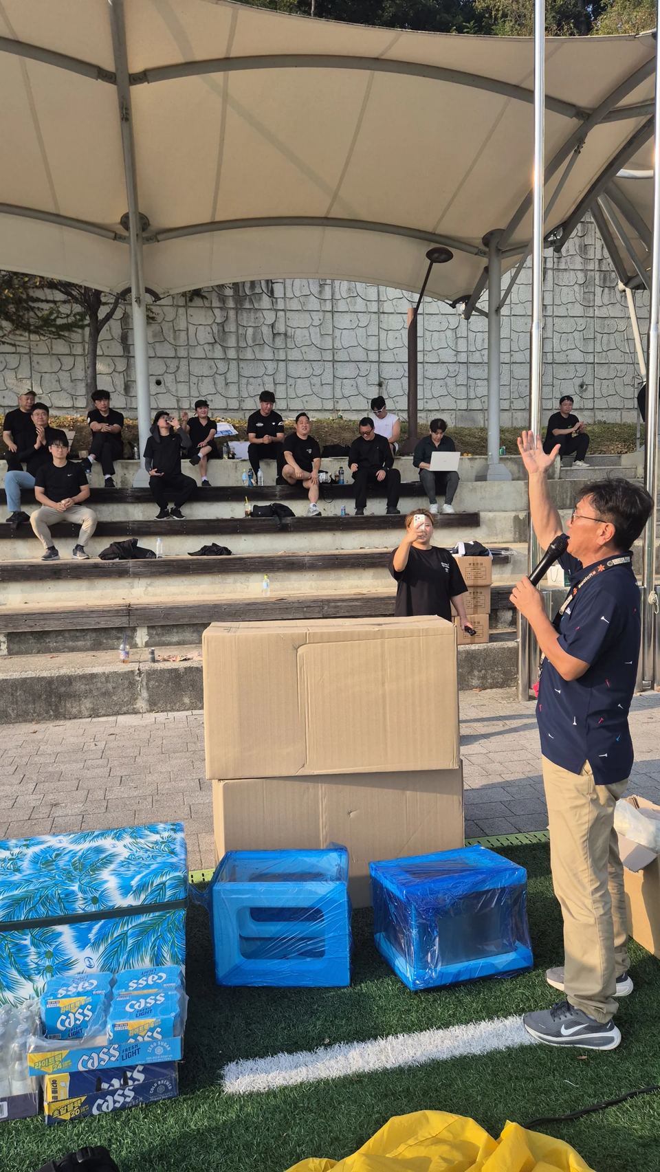 관중석 앞에서 마이크를 들고 말하는 진행자 · 체육 행사