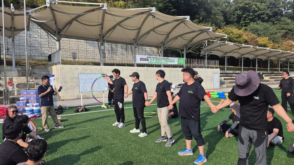 손잡고 선 참가자 줄과 뒤에서 진행하는 모습 · 체육 행사