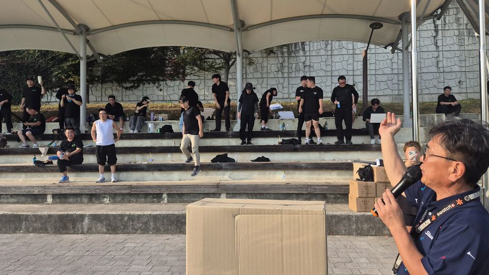 관중석을 향해 손을 들고 마이크로 진행 · 체육 행사