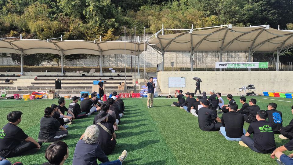 잔디 위에 앉아 진행을 지켜보는 참가자들 · 체육 행사