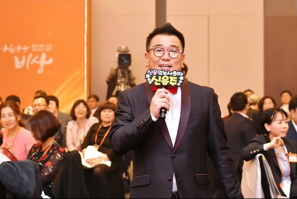 객석 앞에서 마이크로 진행하는 MC