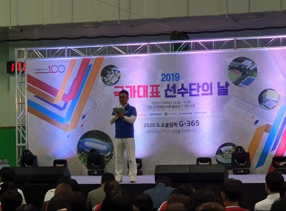 현수막 앞 무대에서 진행하는 장면 · 기업 행사