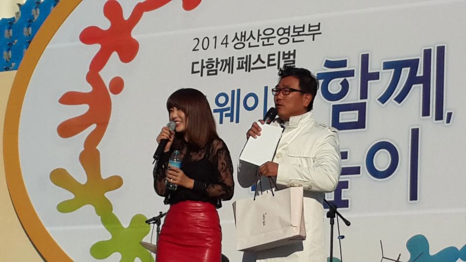 무대에서 마이크를 들고 대본을 든 진행자들 · 기업 행사